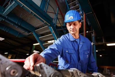Mitarbeiter in der Produktion, fotografiert an seinem Arbeitsplatz