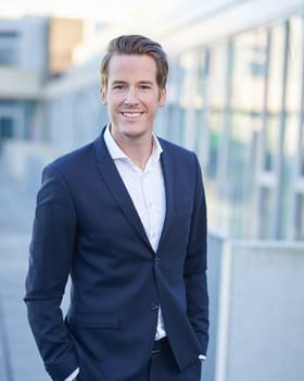 Businessportrait eines Mitarbeiters vor der Bürofassade